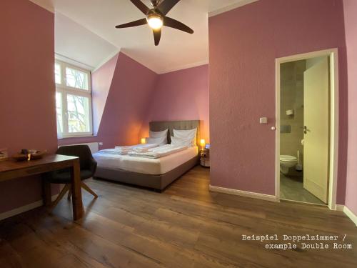 波茨坦Amaroo - Gästehaus Potsdam “Charlottenhof”的一间卧室配有一张床和吊扇