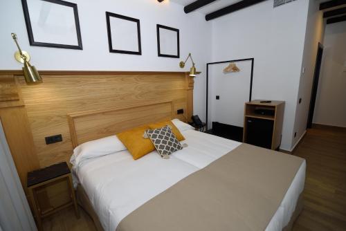 埃尔罗西奥Hostal Rural Santa Habitaciones Aldea del Rocío的卧室配有白色的床和两个枕头