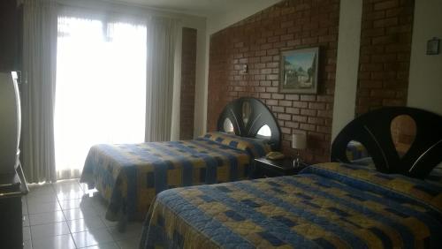 危地马拉马里亚纳佩蒂特住宿加早餐旅馆的酒店客房设有两张床和窗户。