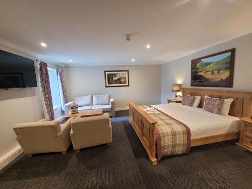 斯通斯通豪斯百思博客酒店的一间卧室配有一张床、一张沙发和一台电视。