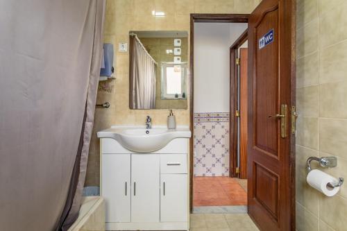 里斯本因卡纳克之家度假屋的一间带水槽和镜子的浴室