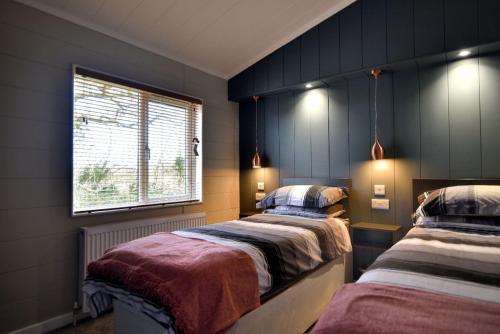 莱姆里吉斯Hazelwood 4 Pinewood Retreat的一间卧室设有两张床和窗户。