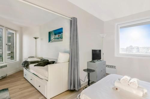 多维尔Nice studio with seaview in Deauville port - Welkeys的白色的卧室设有床和窗户