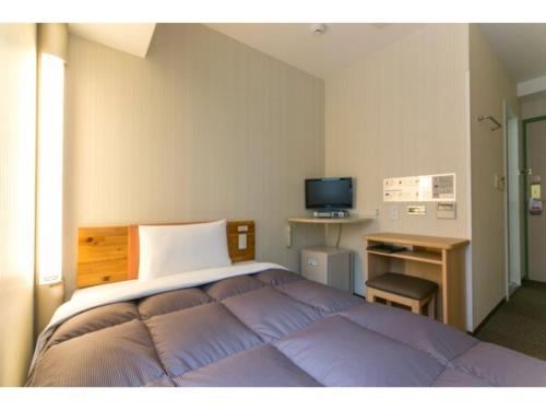 名古屋R&B HOTEL NAGOYA SAKAE HIGASHI - Vacation STAY 40507v的一间卧室配有一张床、一张书桌和一台电视