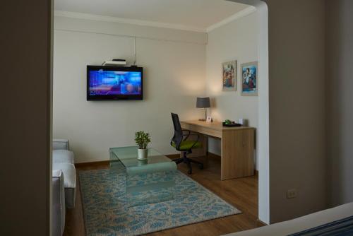 波哥大圣西门酒店的客房设有书桌和墙上的电视。