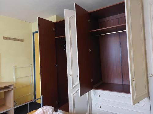 巴塞尔顿Basildon House的一间卧室配有带棕色和白色橱柜的衣柜