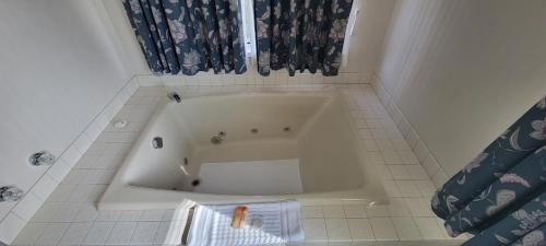 麦基诺城麦基诺城雷鸟酒店的白色瓷砖浴室内的白色浴缸