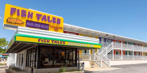 大洋城Fish Tales Boardwalk Inn & Ocean Mecca Motel的鱼的故事商店,前面有标志