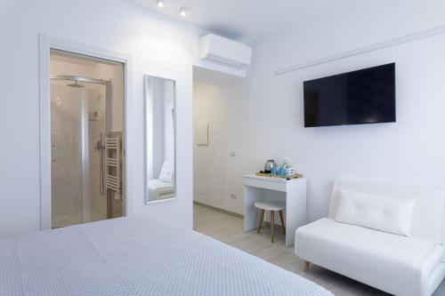 西维尔诺瓦·马尔凯Vista Mare Guest House的白色的卧室配有白色的床和白色沙发