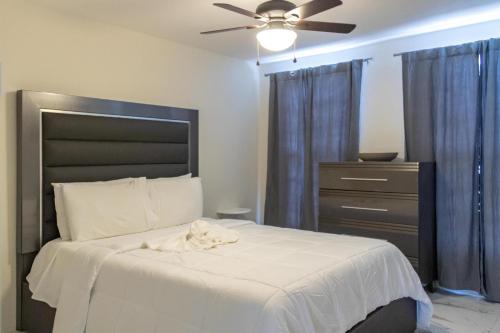 蒙特哥贝C'DaView Apartment Suite的一间卧室配有一张带吊扇和梳妆台的床。