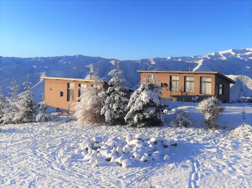 波特雷里约斯ArribadelValle - Casas de Altura的雪地里的房子,雪地里留下脚印