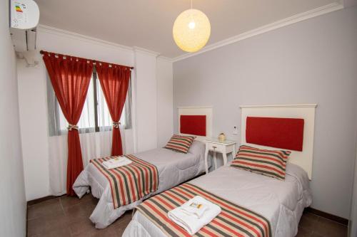 圣达菲A & P的配有红色窗帘的客房内的两张床