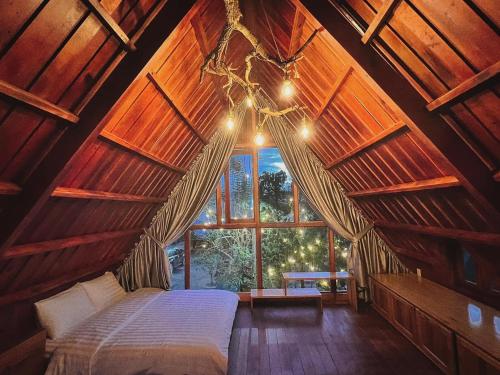 大叻贝瑞瓦利山林小屋的一间带床的卧室,位于带窗户的房间内