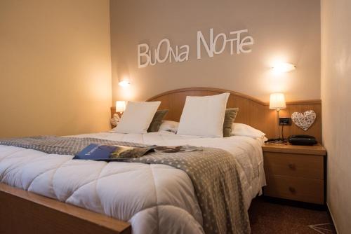 拉瓦尼亚提古丽奥酒店的酒店客房的墙上设有一张带标志的床