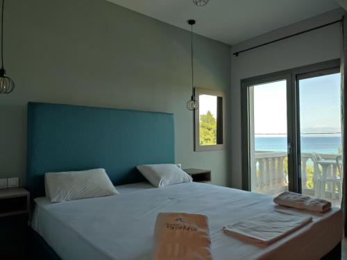 尼亚·卡利克拉提亚帕拉克提奥酒店的一间卧室设有一张床,享有海景
