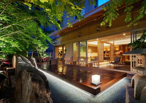 东京东京庭之酒店的一座室内花园,花园中设有木凳,位于房子的中间
