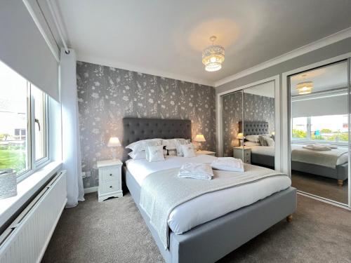 塞拉戴克Dragonfly - HOT TUB luxury two bedroom cottage的一间卧室设有一张床和一个大窗户