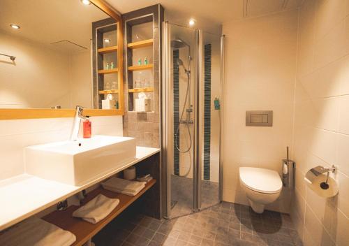 萨翁林纳赌场Spa酒店的一间带水槽、淋浴和卫生间的浴室