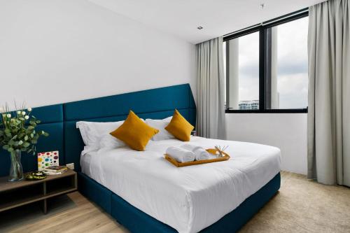 八打灵再也Lumi Tropicana的卧室配有蓝色和白色的床以及黄色枕头