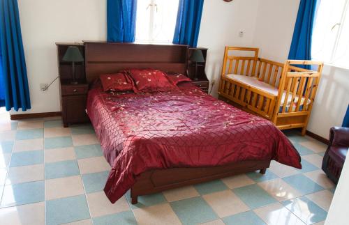 特鲁欧克比赫斯The Impala Mauritius Bed & Breakfast的一间卧室配有一张床、一把椅子和蓝色窗帘