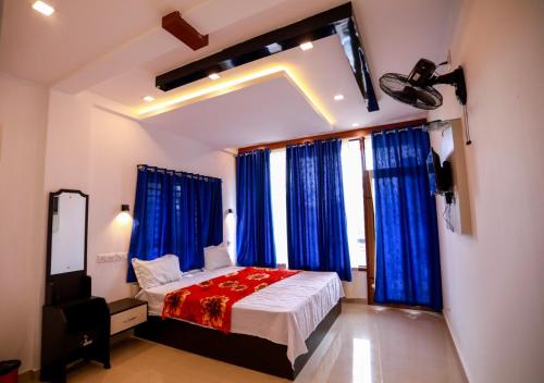 ThirunelliDakshinakasi Guest House的一间卧室配有一张蓝色窗帘的床