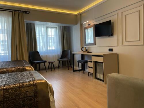 伊斯坦布尔Azra Sultan Hotel & Spa的酒店客房配有一张床、一张书桌和一台电视。
