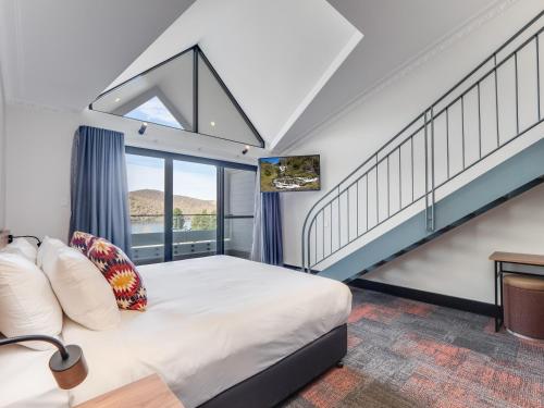 金德拜恩班卓帕特森旅馆的一间卧室设有一张床和一个楼梯