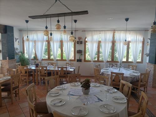 GaleraHotel Galera的用餐室设有桌椅和窗户。