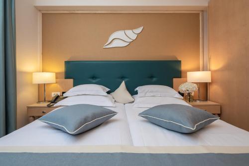 图彻皮Aparthotel Flora的一张带两个枕头的大床和绿色床头板