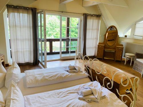 GrüssowLandhaus am Achterwasser mit Bootssteg的一间卧室设有两张床和大窗户