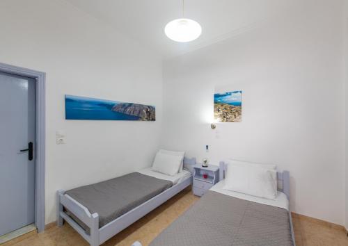 佩里萨SantoriniNY的一间卧室设有两张床和窗户。