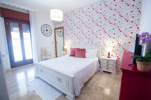 阿尔巴塔克斯B&B Calamoresca的卧室配有白色床,墙上挂着红色的心