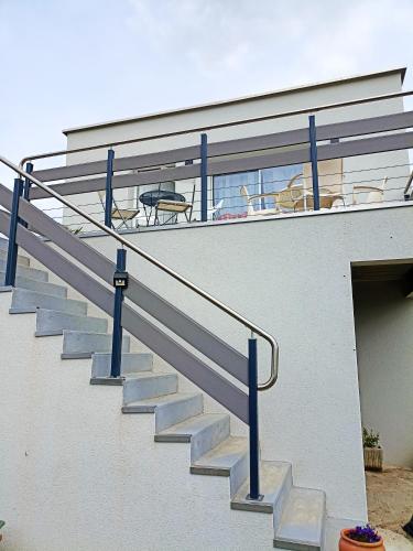 阿纳齐Appartement de 2 chambres avec terrasse amenagee et wifi a Arnage的建筑旁边设有蓝色栏杆的楼梯