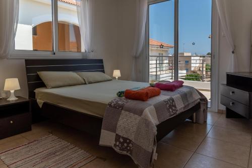 帕拉利米尼Mythical Sands Resort & Spa, Evilion Apartment的一间卧室设有一张床和一个大窗户