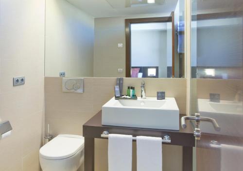 阿尔赫西拉斯Sercotel Aura Algeciras的一间带水槽、卫生间和镜子的浴室