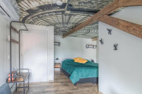 多克姆Boutiquehotel Dokkum的一间卧室设有绿色的床和木制天花板