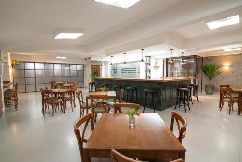 普鲁登特总统城EKO HOTEL的一间带木桌椅的餐厅和一间酒吧