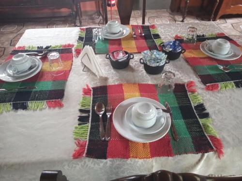 圣巴巴拉Pousada Capão da Coruja的桌子上带盘子和餐具的桌子