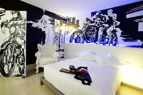 马德里多米西那酒店的卧室配有一张床和摩托车绘画