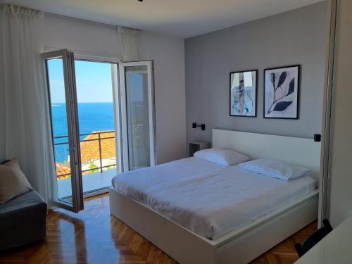 米利尼隆扎公寓的一间卧室配有一张床,享有海景
