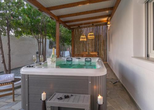 阿达玛斯Kallia's Suites Milos的带浴缸的浴室,位于带蜡烛的庭院