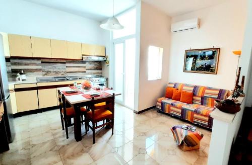 切萨雷奥港Zuccaro Apartment的厨房以及带桌子和沙发的用餐室。