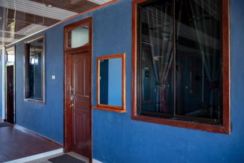 LagudriYuni Surf House的蓝色的房间,设有门窗