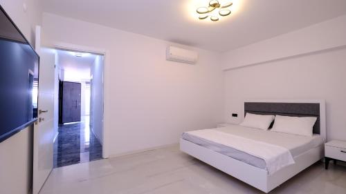 库萨达斯Oksa Apart的白色卧室配有床和平面电视