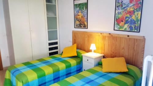 坎布里尔斯Miramar Serveis -Port Marino的一间卧室设有两张黄色和蓝色的床