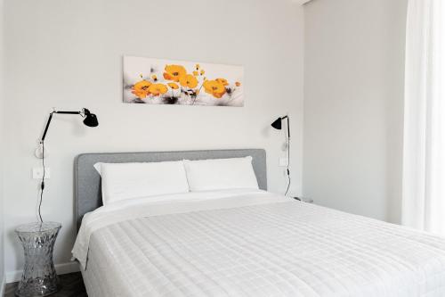 维罗纳HomeThirtyFour的白色卧室配有一张床,墙上挂着一幅画