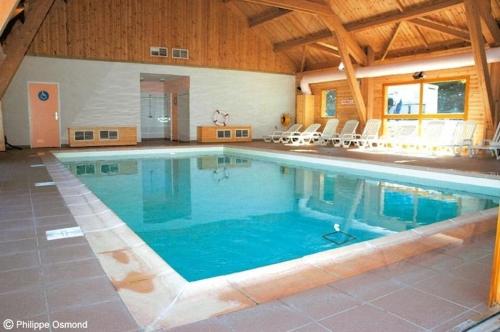 德沃吕伊Petit Chalet 5 pers piscine sauna 2 chambres的大型建筑中的大型游泳池