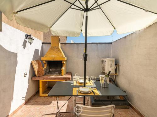 贡内萨Maty's House - Dreaming Holiday的露台上的桌子和遮阳伞