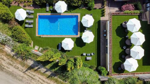 赫罗纳科斯塔贝拉酒店的享有带白色遮阳伞的游泳池的顶部景致