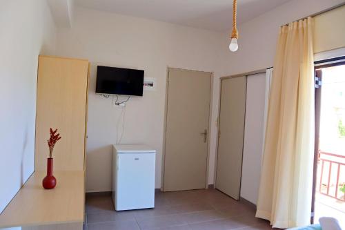 阿马林索斯Το Κοράλι的一间设有冰箱和墙上电视的客房